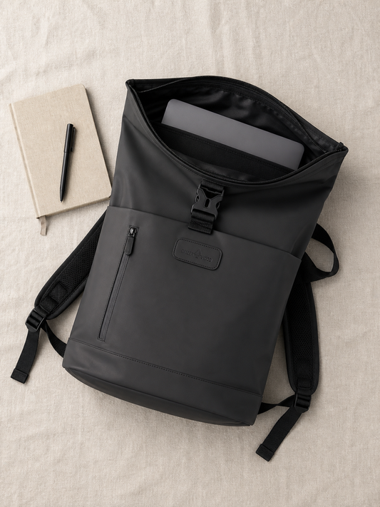 Black roll-top backpack open flat showing the padded laptop compartment