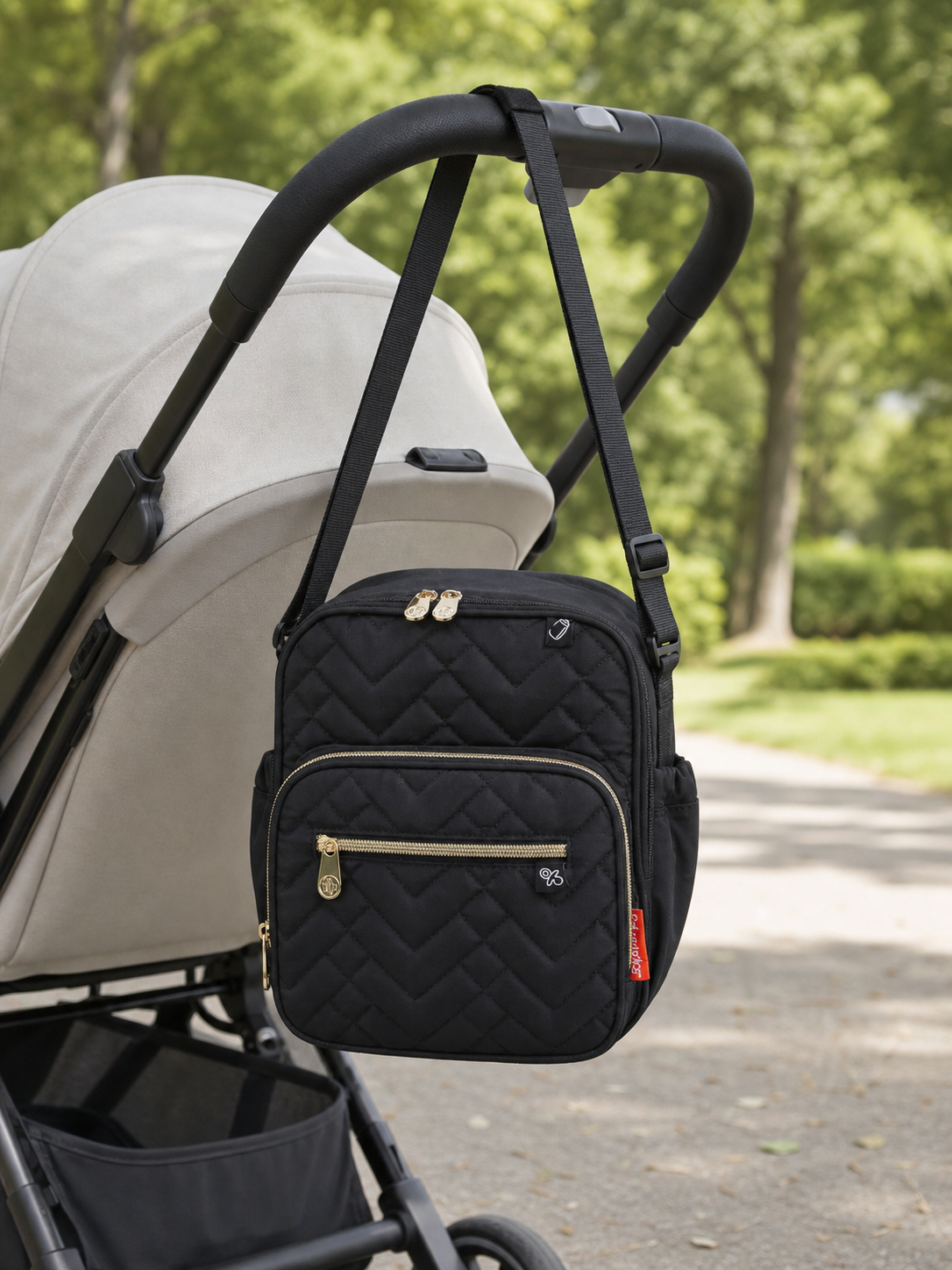 Black Fisher-Price quilted cooler bottle bag hanging from a stroller