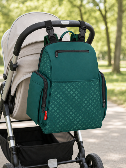 Green Fisher-Price Gemma diaper backpack hanging from a stroller