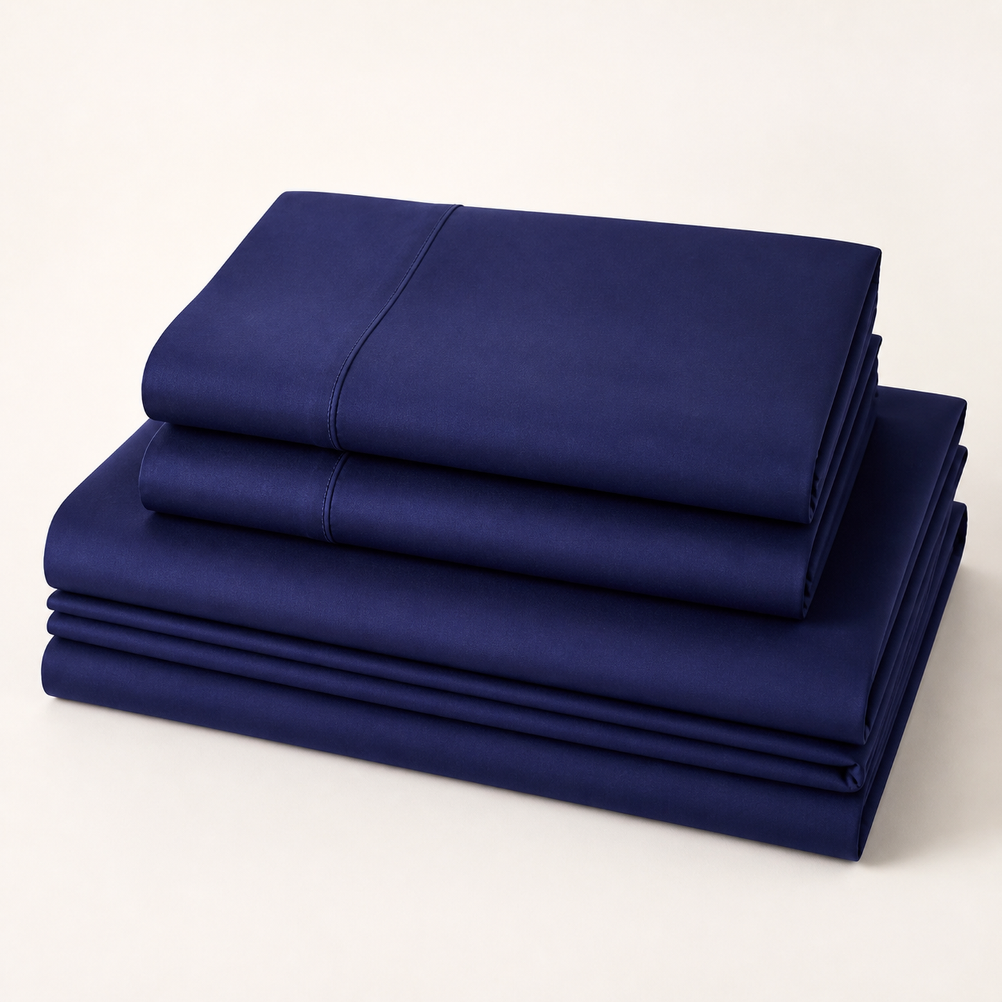 Navy blue 600 thread count percale Queen sheet set folded and stacked on a white background