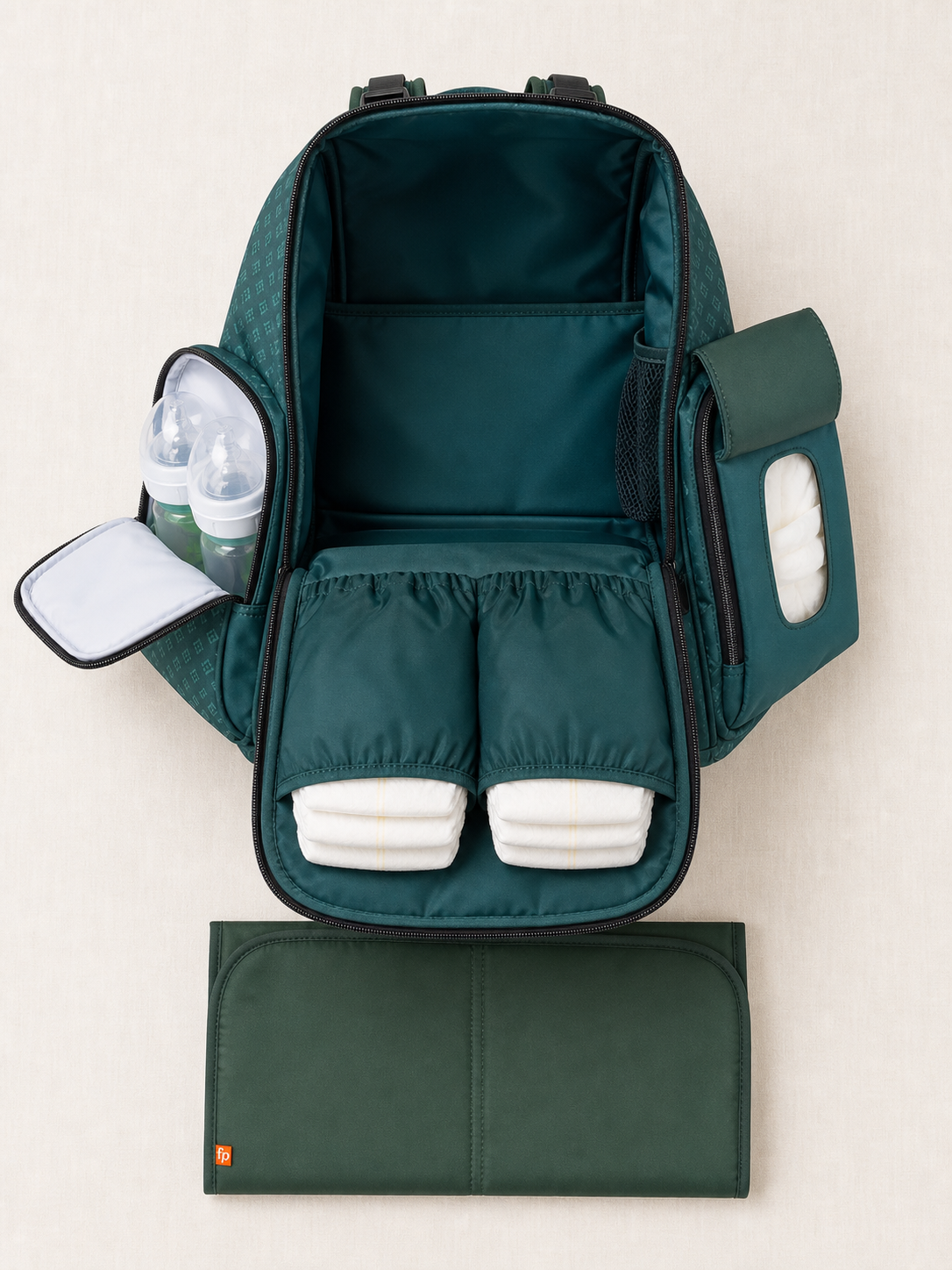 Green diaper backpack open showing organiser pockets and changing mat