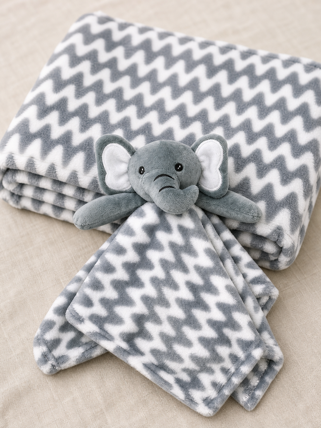 Detail of the grey elephant lovey and chevron print blanket