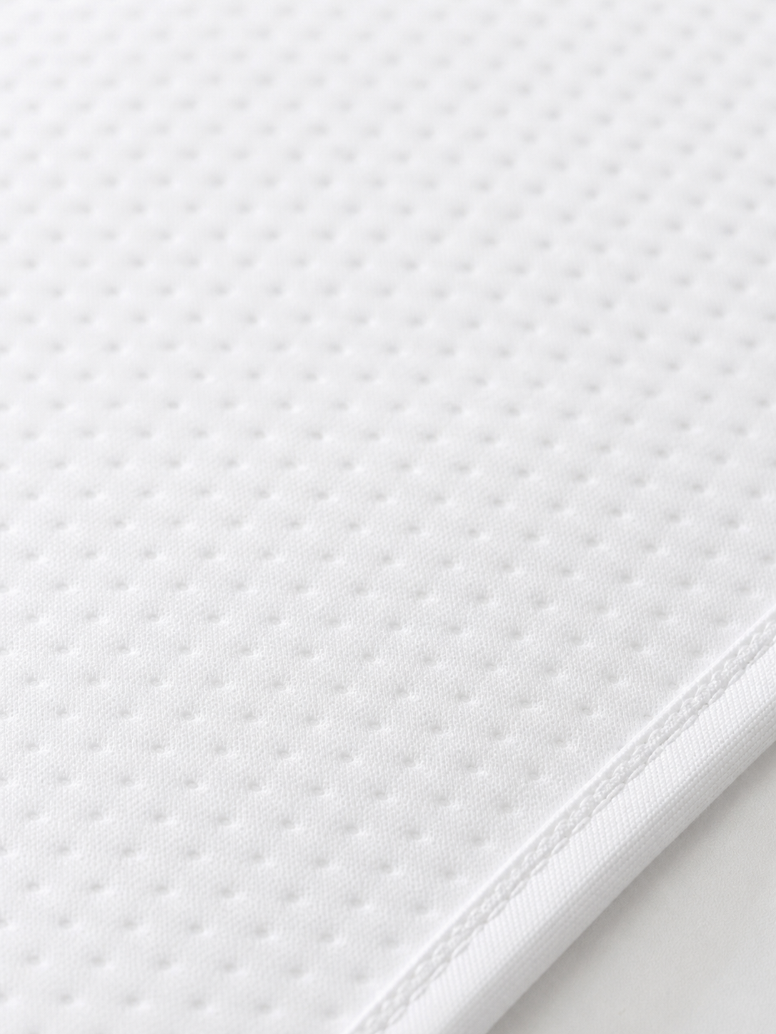 Macro detail of the quilted surface on the crib mattress protector