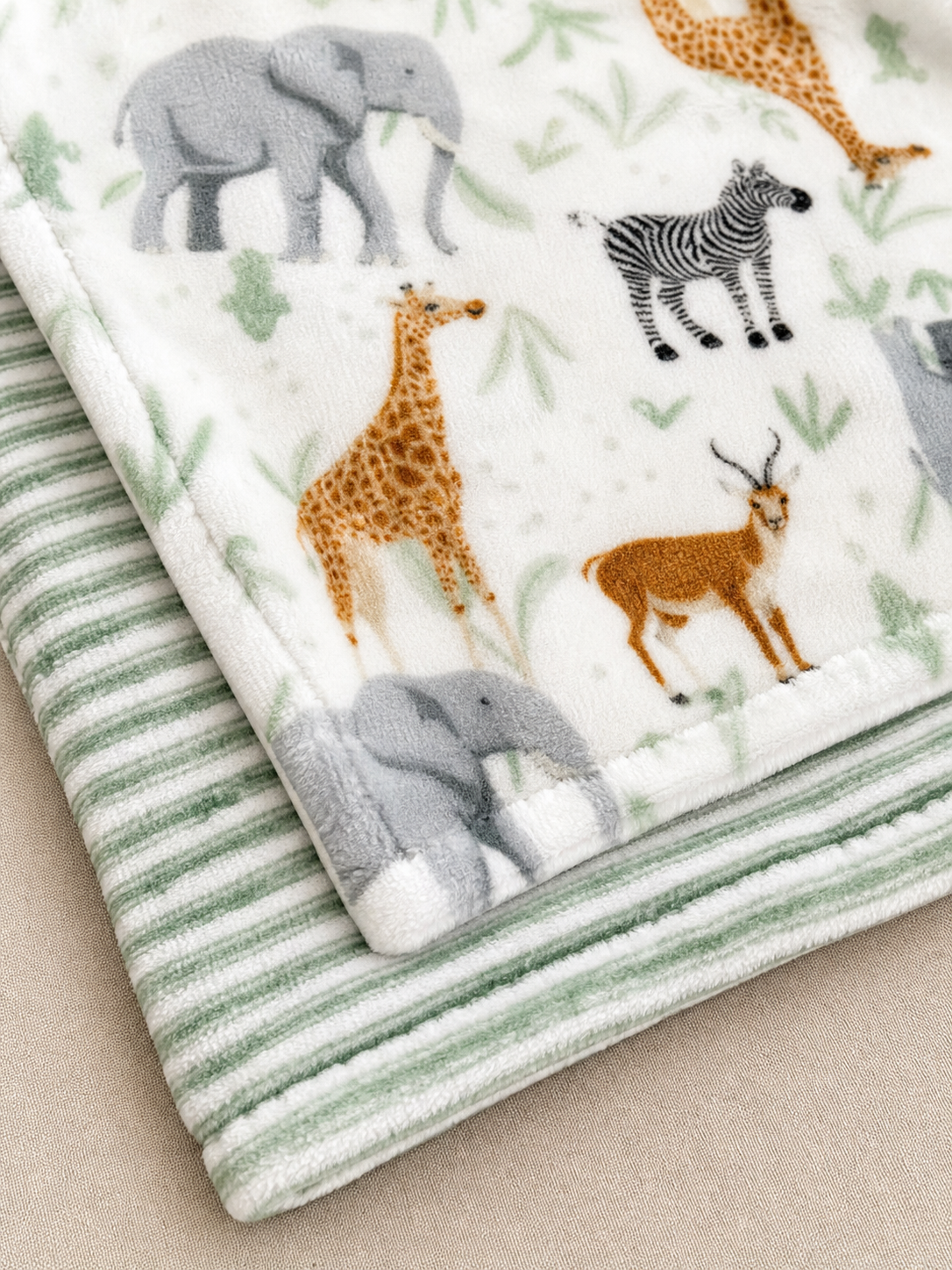 Texture detail of the sage safari print and stripe blankets