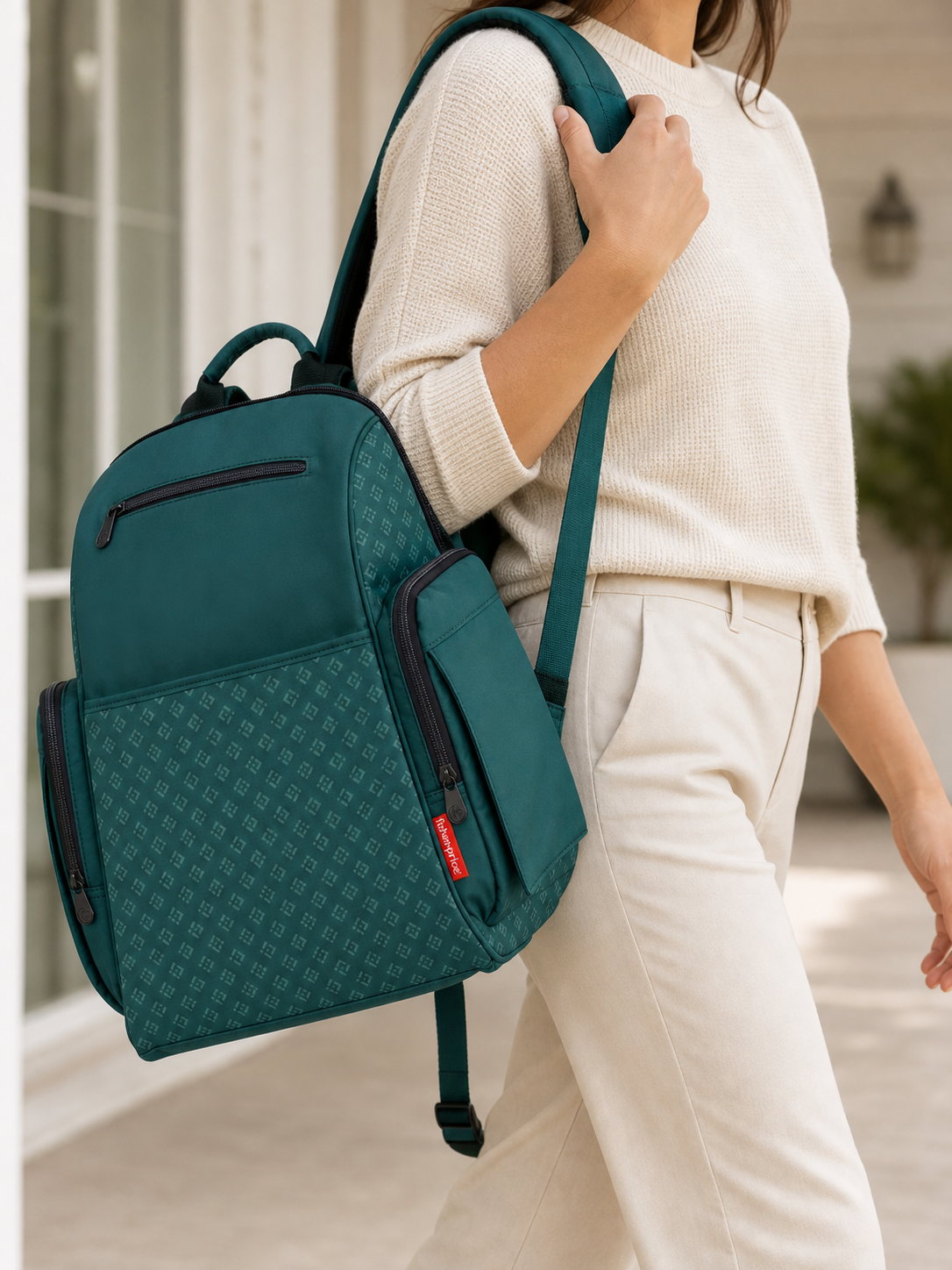 Green diaper backpack carried over one shoulder
