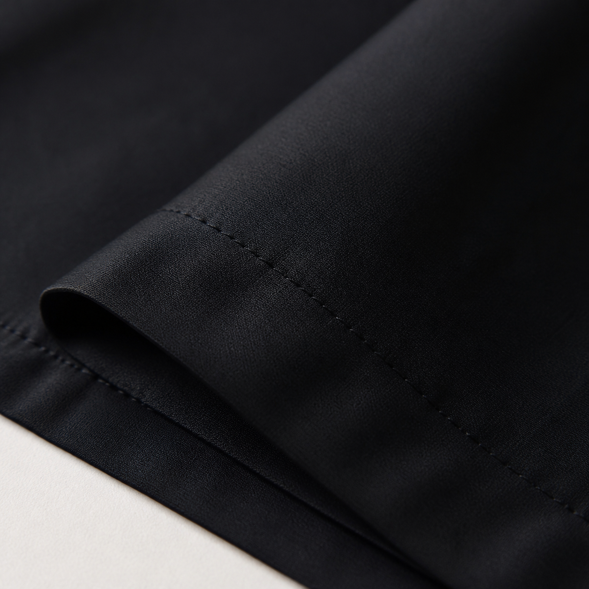 Close-up of the black 600 thread count percale weave and stitched hem
