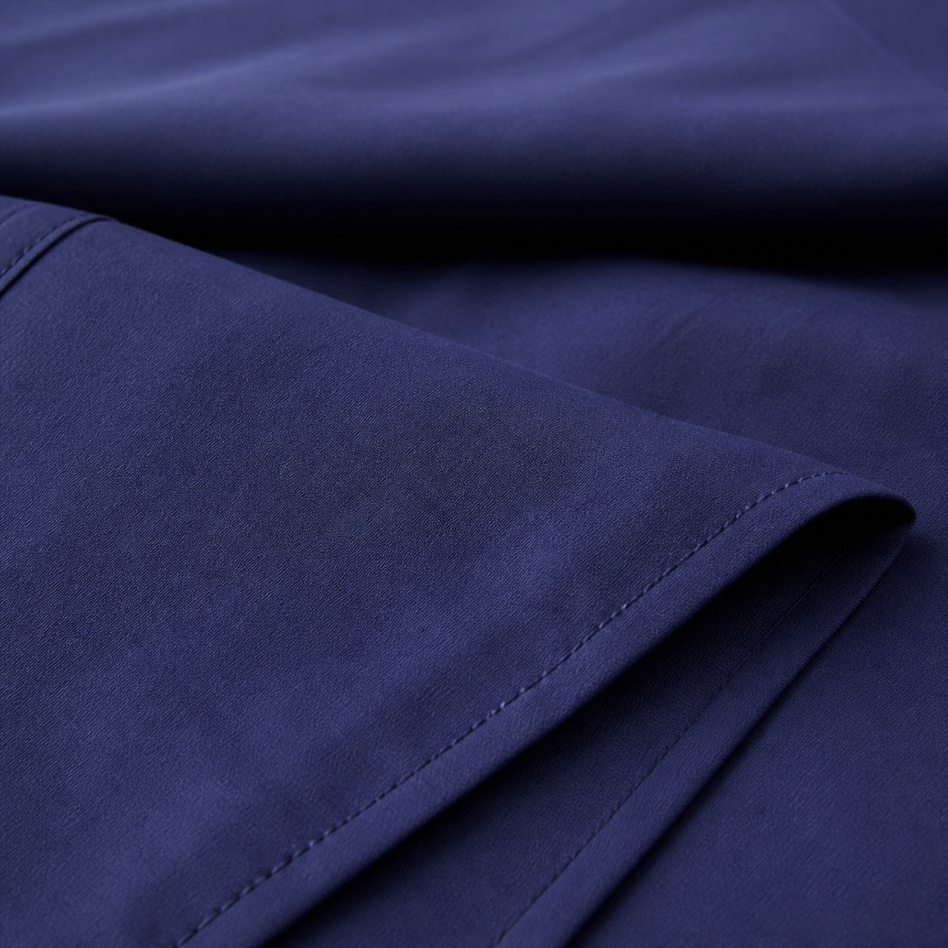 Close-up of the navy blue 600 thread count percale weave and stitched hem