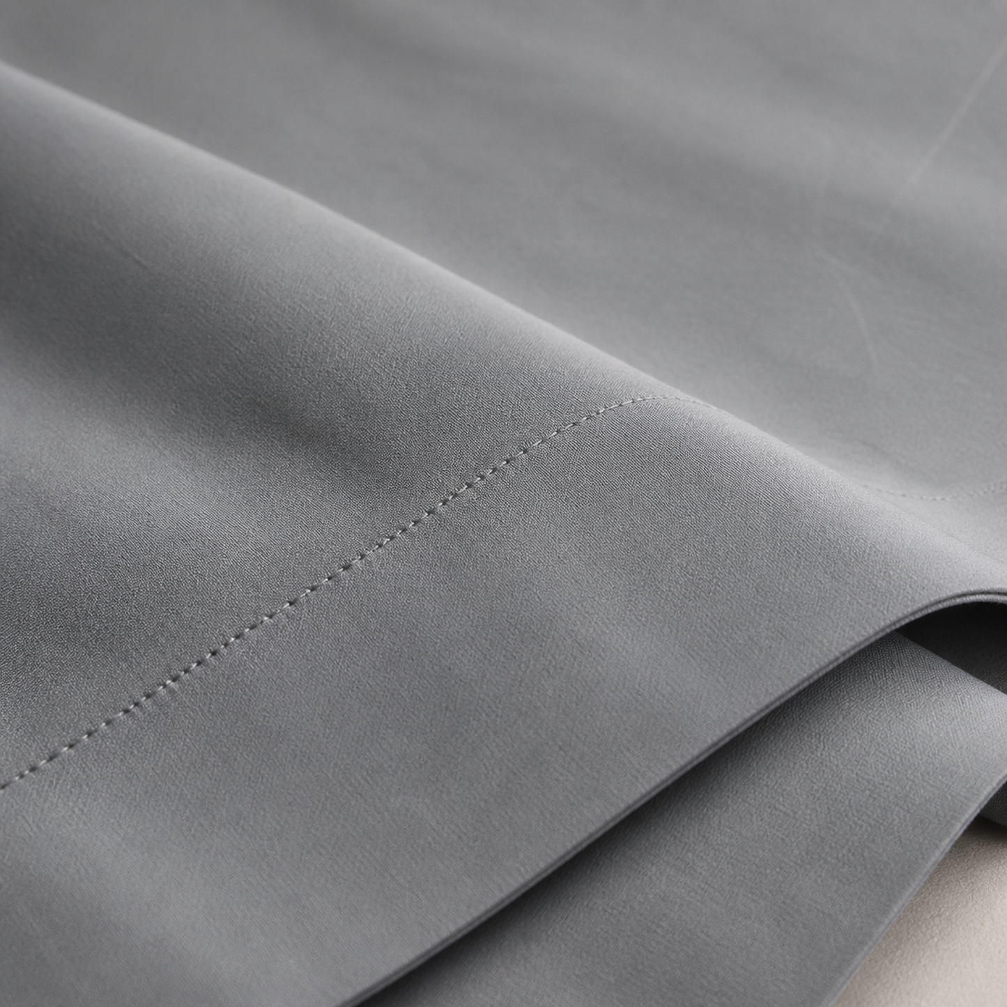 Close-up of the grey 600 thread count percale weave and stitched hem