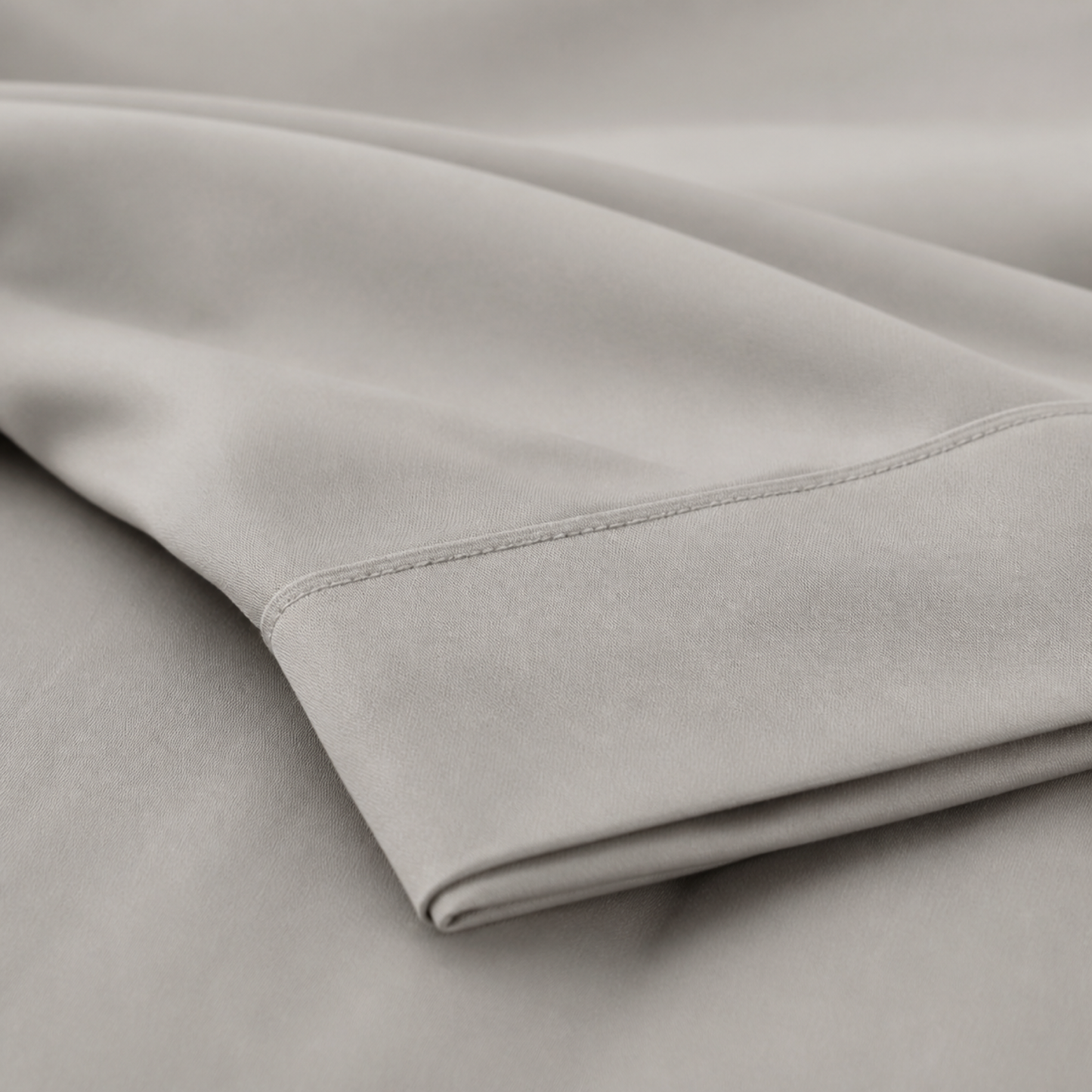 Close-up of the taupe 600 thread count percale weave and stitched hem