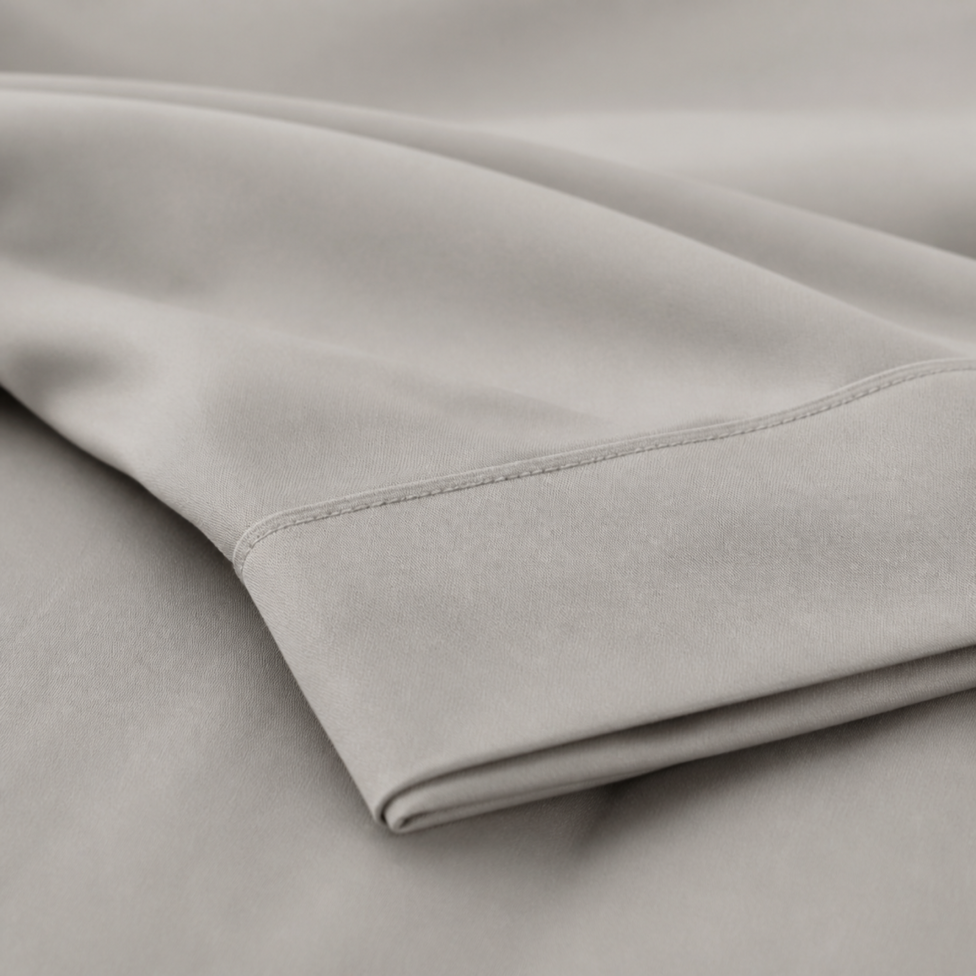 Close-up of the taupe 600 thread count percale weave and stitched hem