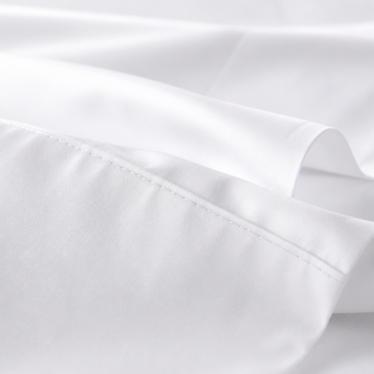 Close-up of the white 600 thread count percale weave and stitched hem