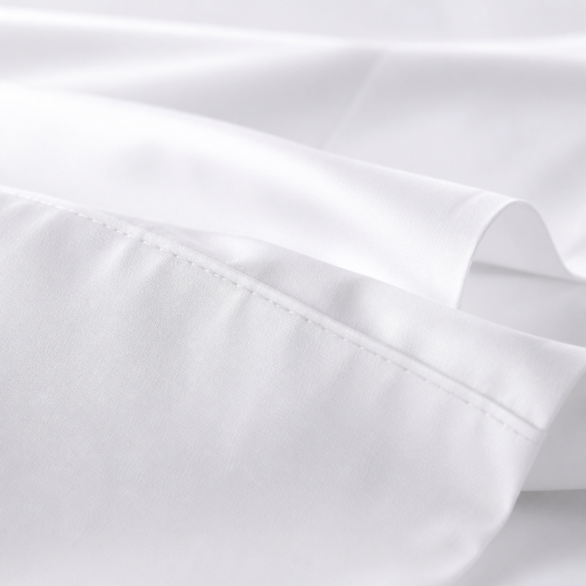 Close-up of the white 600 thread count percale weave and stitched hem