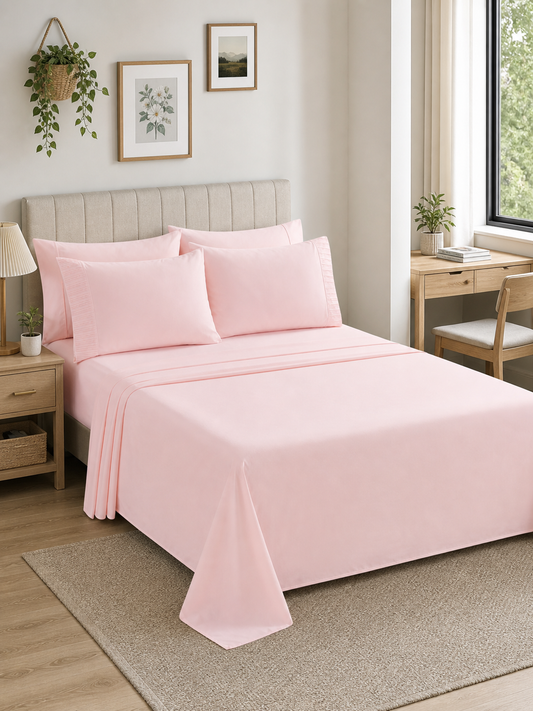 Pink 6-piece Queen sheet set made up on a bed