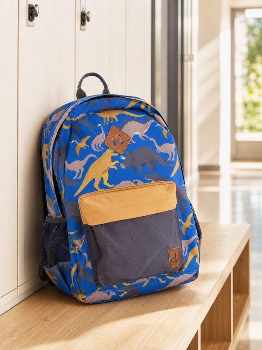 Blue dinosaur print kids backpack in a school hallway