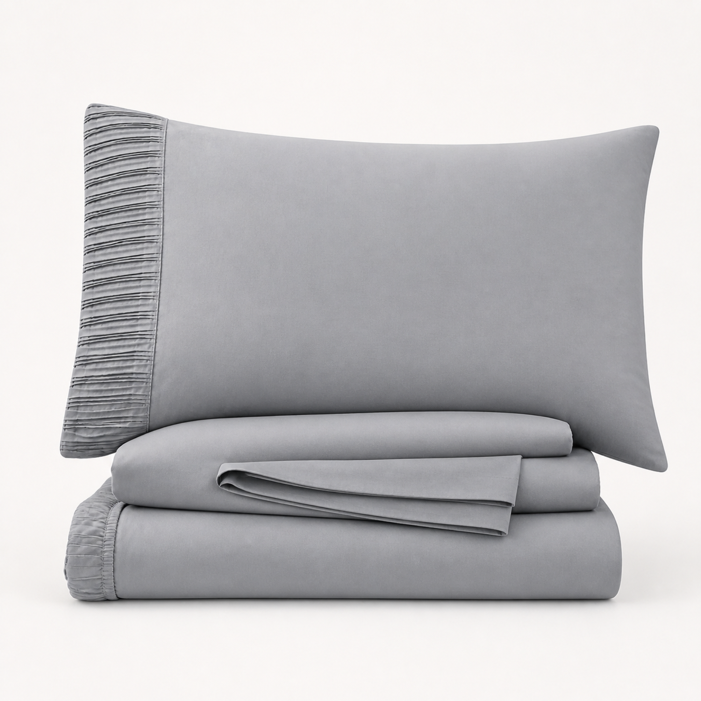 Grey 4-piece Twin XL sheet set folded and stacked with pleated pillowcase on a white background