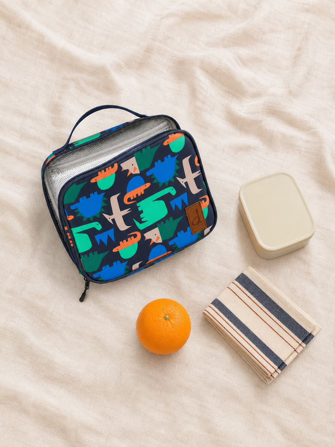 Flat lay of the blue dinosaur snack box with lunch items
