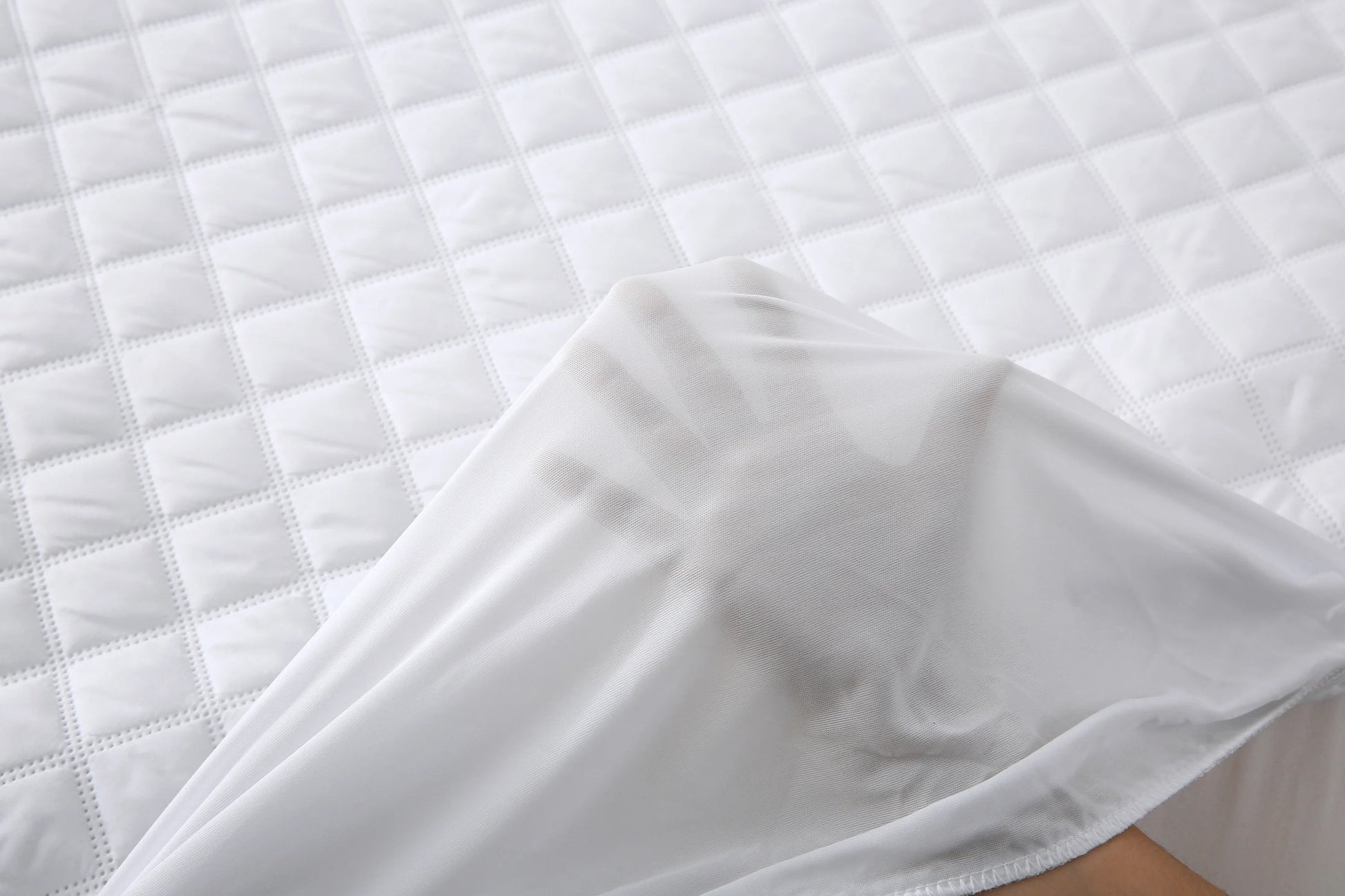 Close-up of the quilted waterproof mattress pad surface and elasticated skirt