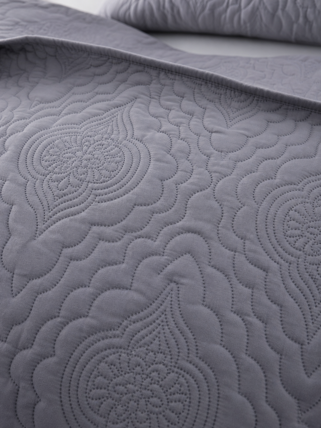 Close-up of the embossed pattern on the grey quilt