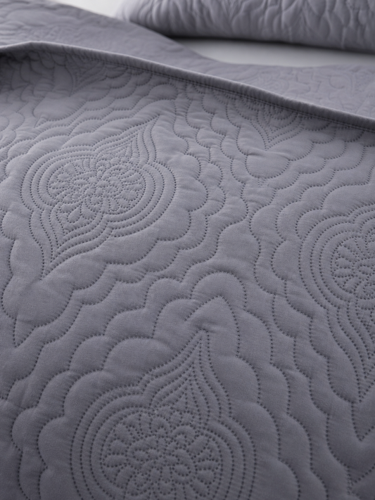 Close-up of the embossed pattern on the grey quilt