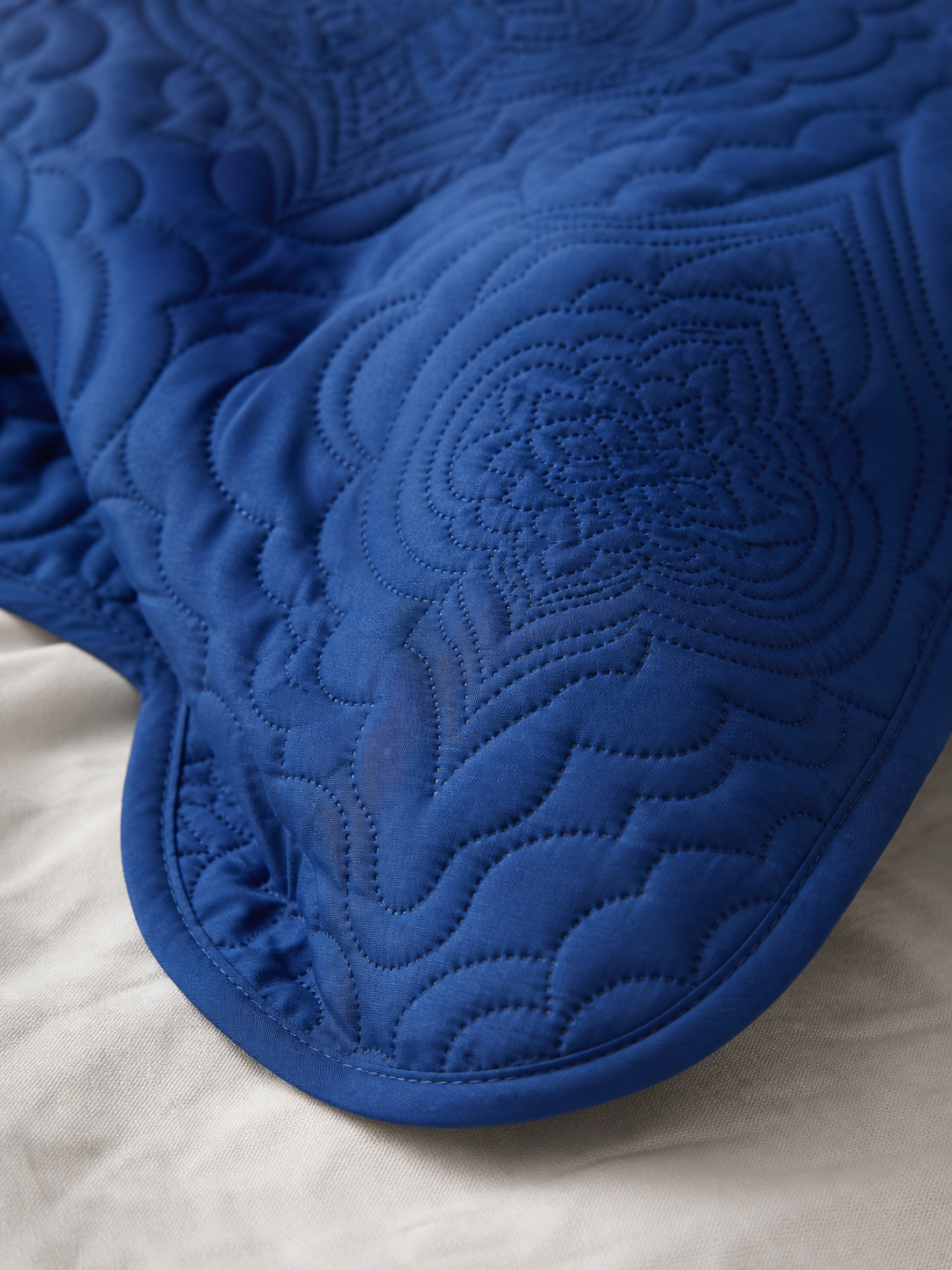 Close-up of the embossed pattern on the navy blue quilt