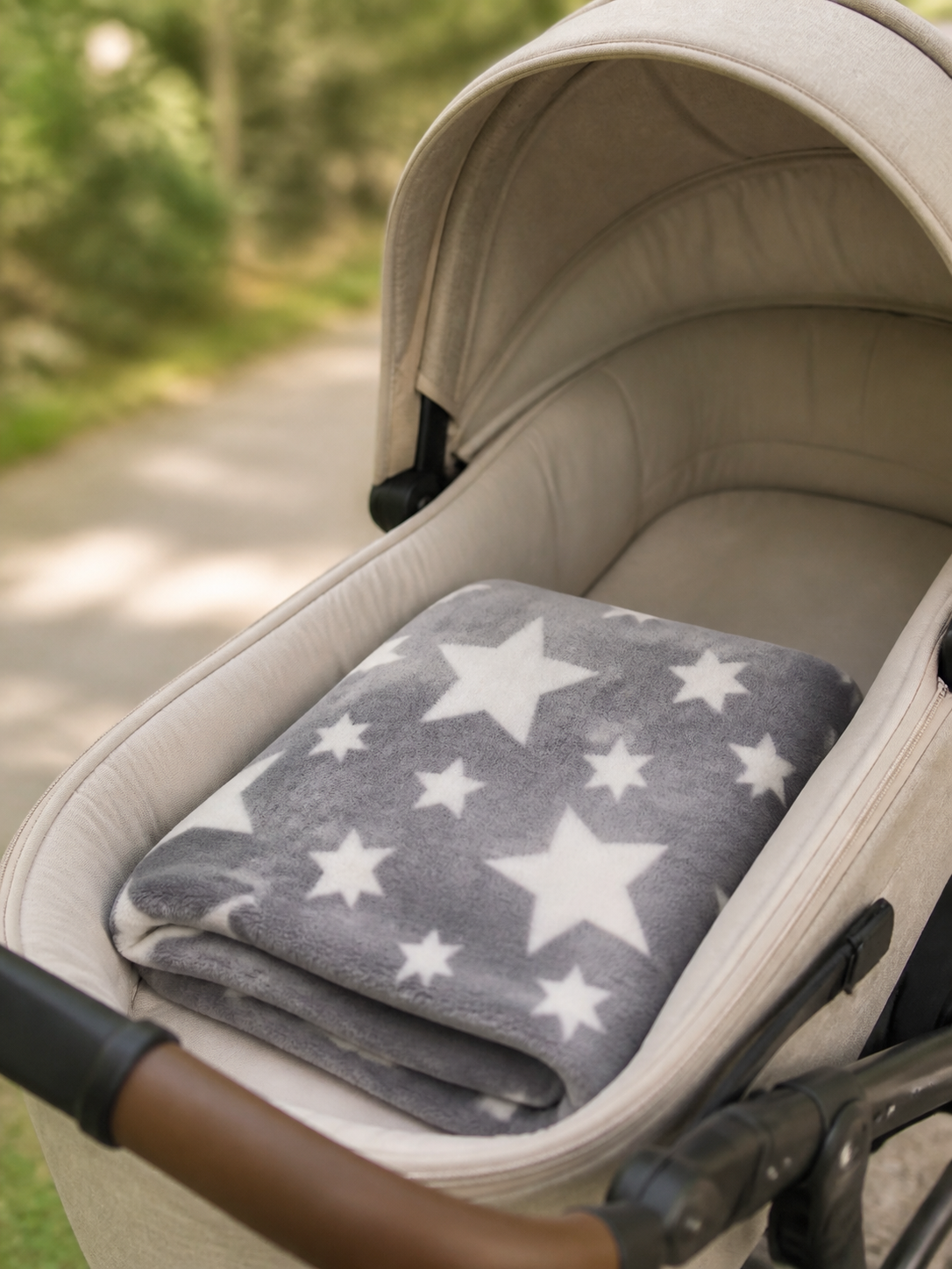 Grey star print flannel fleece baby blanket draped over a stroller