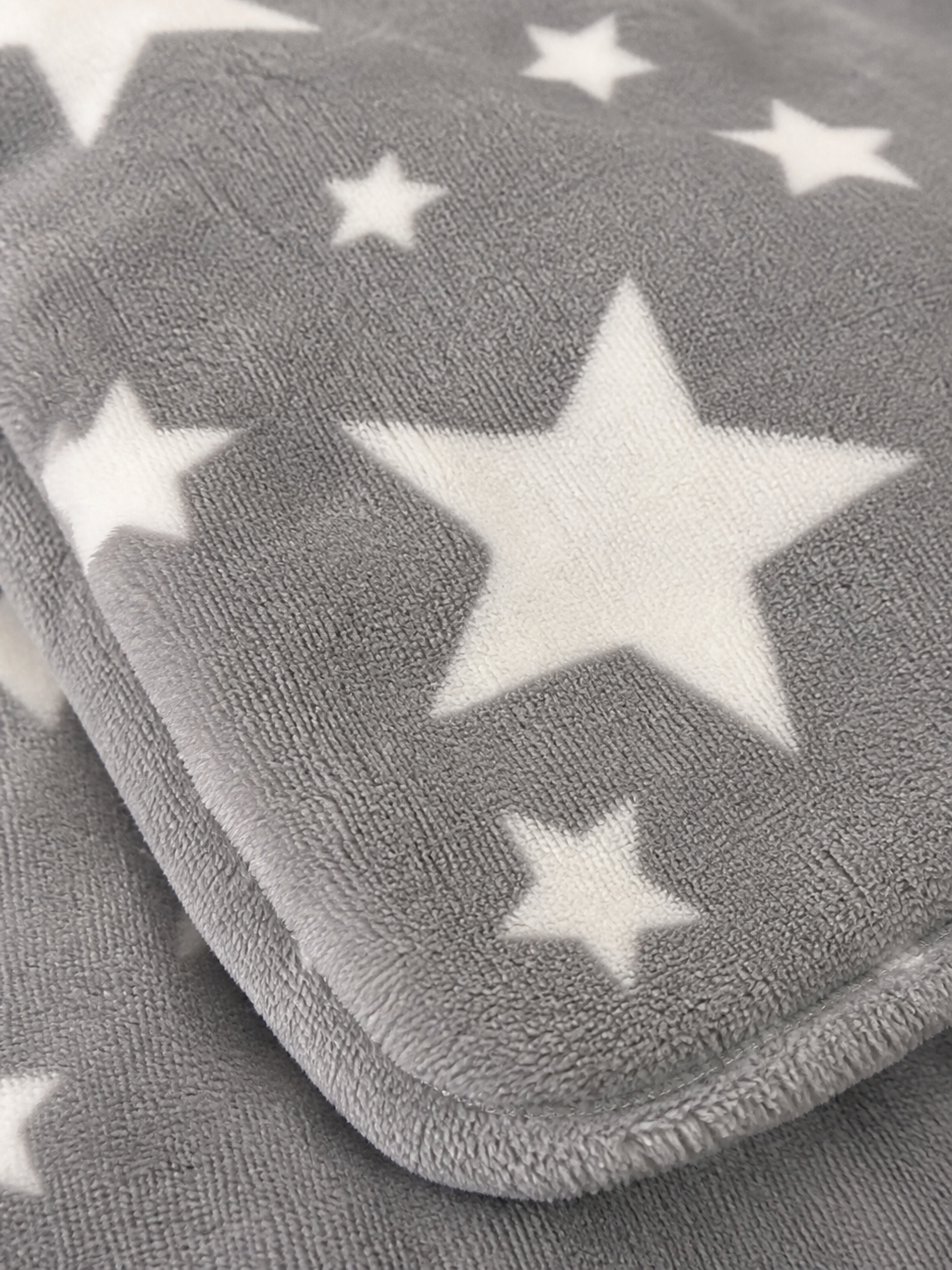Grey star print flannel fleece fabric texture close-up