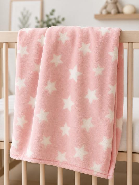 Pink star print flannel fleece baby blanket on a crib rail