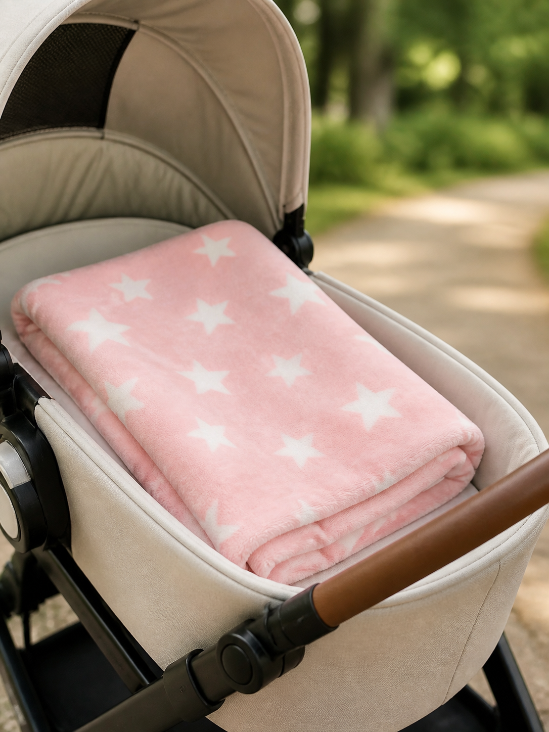 Pink star print flannel fleece baby blanket draped over a stroller