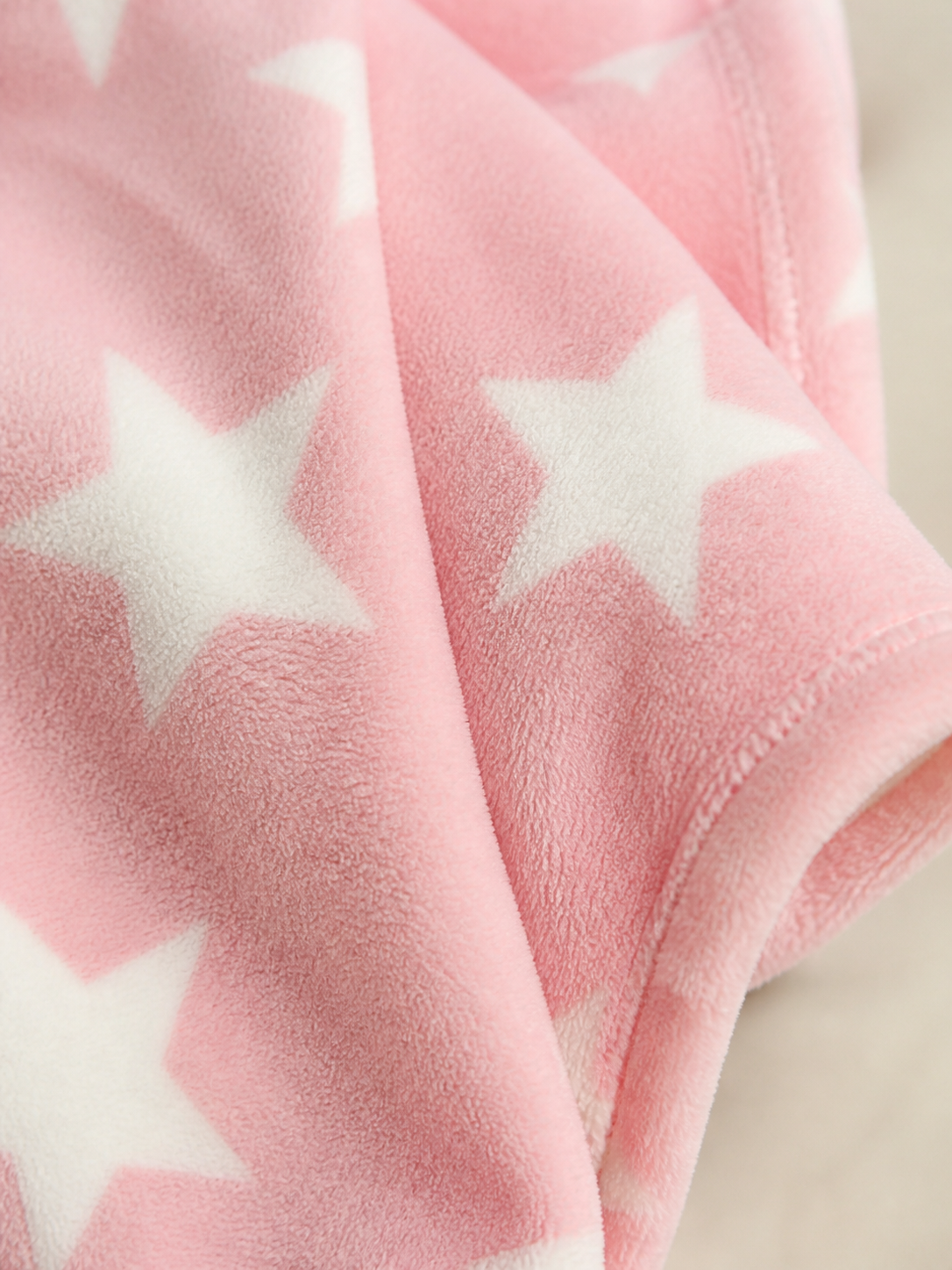 Pink star print flannel fleece fabric texture close-up